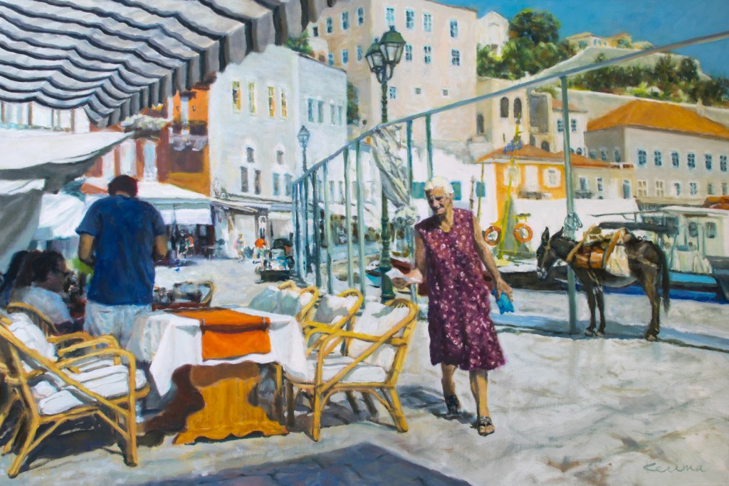 Woman walking along boardwalk in Hydra, Greece